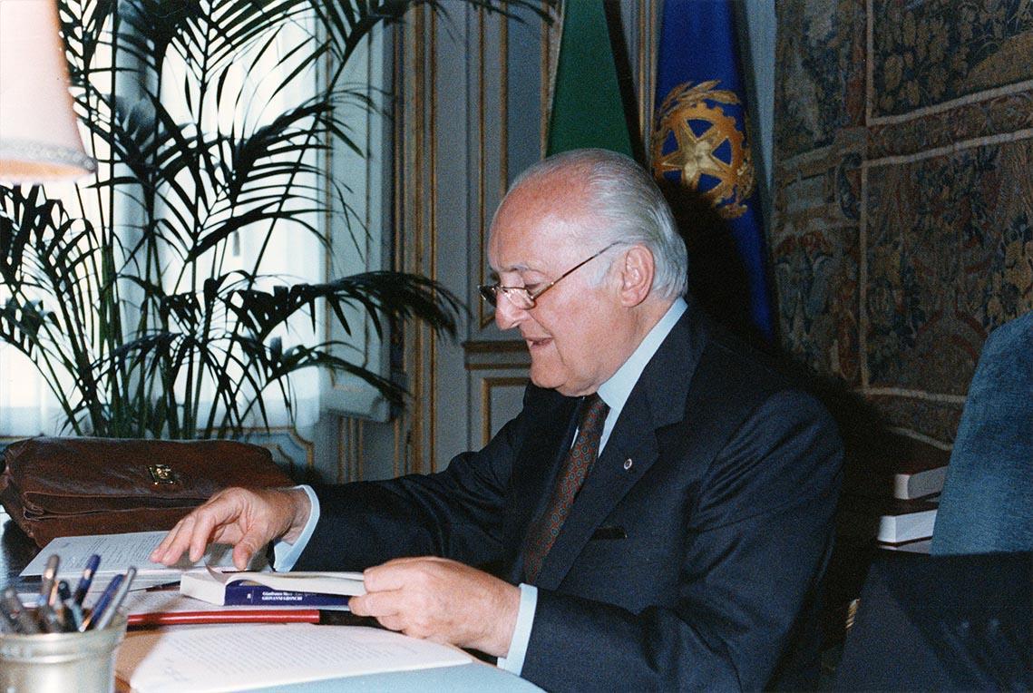 Il Presidente Scalfaro mentre legge il volume: Giovanni Gronchi, una democrazia più vera, presentato dall' on. Gianfranco Merli ed Emo Sparisci, durante l'udienza