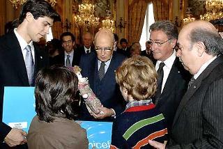 Il Presidente Giorgio Napolitano, nella foto con il Presidente dell'UNICEF Antonio Sclavi, i testimonial Lino Banfi e Roberto Bolle, riceve da parte di alcuni bambini una &quot;Pigotta&quot; la bambola simbolo del progetto di vaccinazione UNICEF