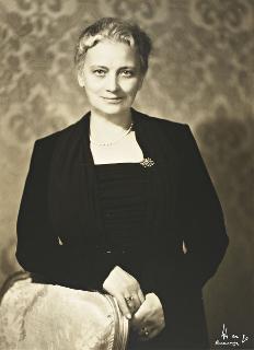 Ida Einaudi Pellegrini ritratta in abito nero e girocollo di perle