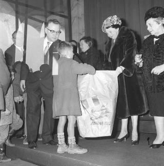 Distribuzione da parte della signora Segni di pacchi dono ai bambini poveri delle borgate romane, Roma, EUR, palazzo della Civiltà del lavoro