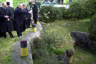 Il Presidente Ciampi, con a fianco il Presidente della Repubblica Ellenica Konstantinos Stephanopoulos, lascia cadere un fiore nella fossa in cui furono fucilati e ammassati i corpi degli ufficiali italiani
