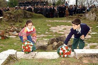 Due Bambini, uno italiano e uno tedesco depongono due mazzi di fiori sui resti dei gradini dell'Altare della Chiesa di S. Martino