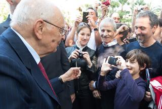 Il Presidente Giorgio Napolitano attende che un giovane visitatore scatti una fotografia